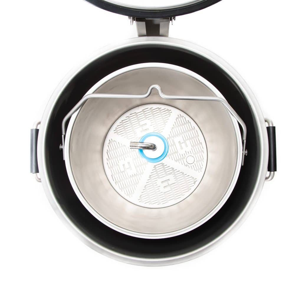 Close-up of a stainless steel pressure cooker lid with vent and inner ring.