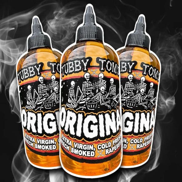 Three orange dropper bottles with a skeleton artwork label and bold white lettering, set against a smoky black background.